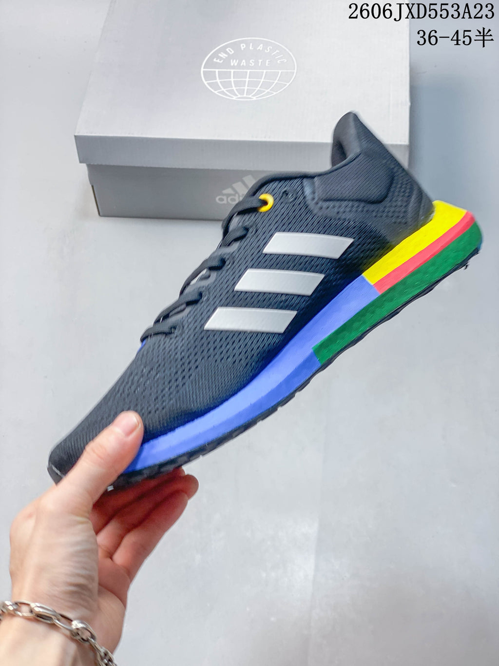 Side profile of the charcoal Adidas PureBoost 21 with white stripes and multicolor sole