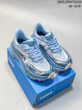 Pair of light blue and white patterned HOKA Stinson 7 trail running shoes on a blue box