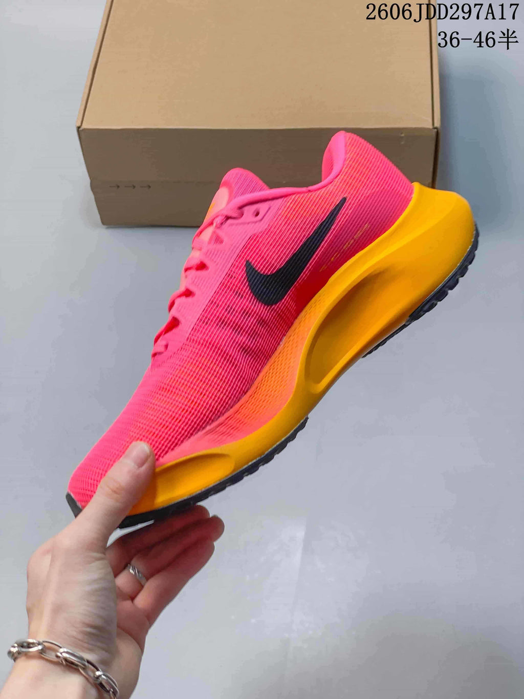 Side view of a pink Nike Zoom Fly 5 with black Swoosh and orange midsole