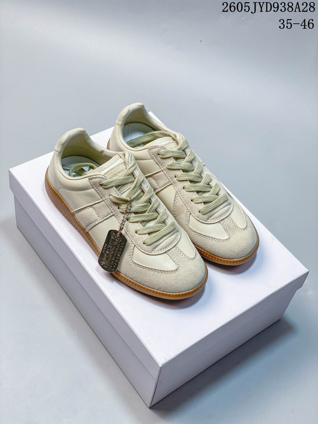 Cream low-top sneakers with textured panels and gum-colored soles on a box