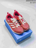 Pair of red Adidas Originals PR SFTM low-top sneakers with cream laces on a blue box