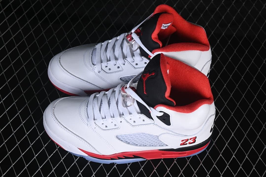 Pair of white, red, and black Air Jordan 5 Retro sneakers