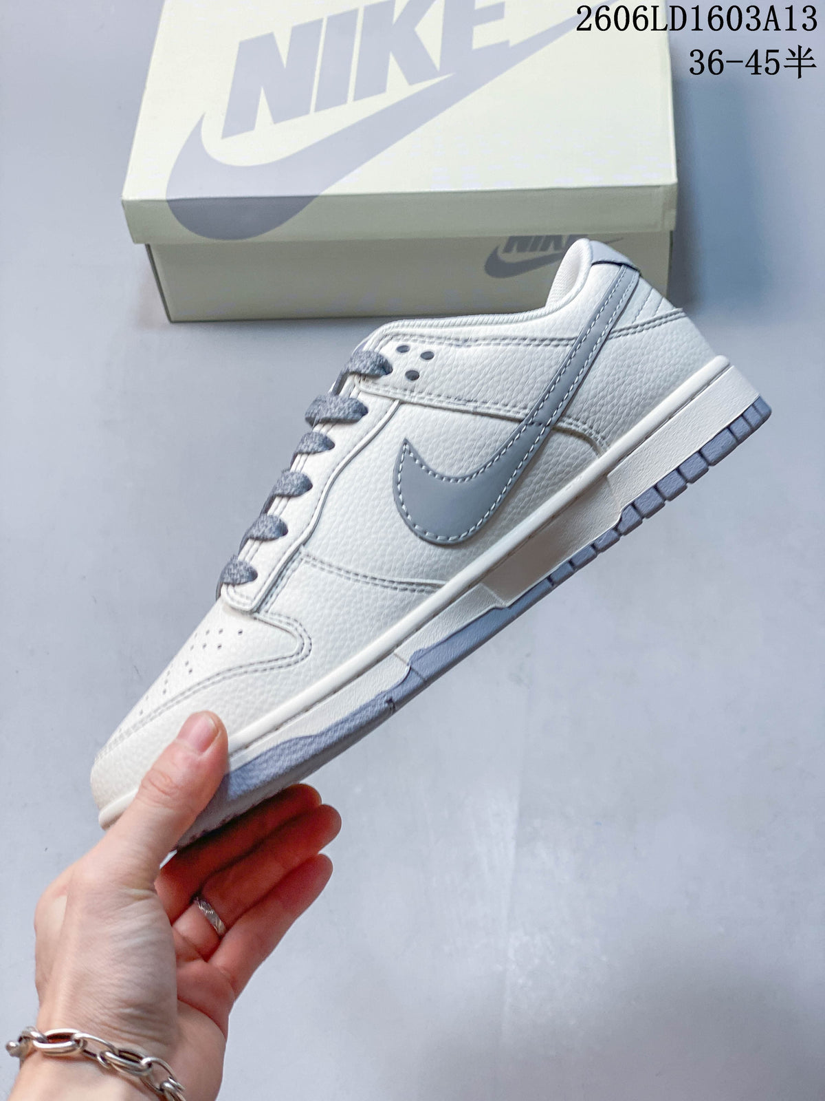 Side view of the cream and grey low-top sneaker