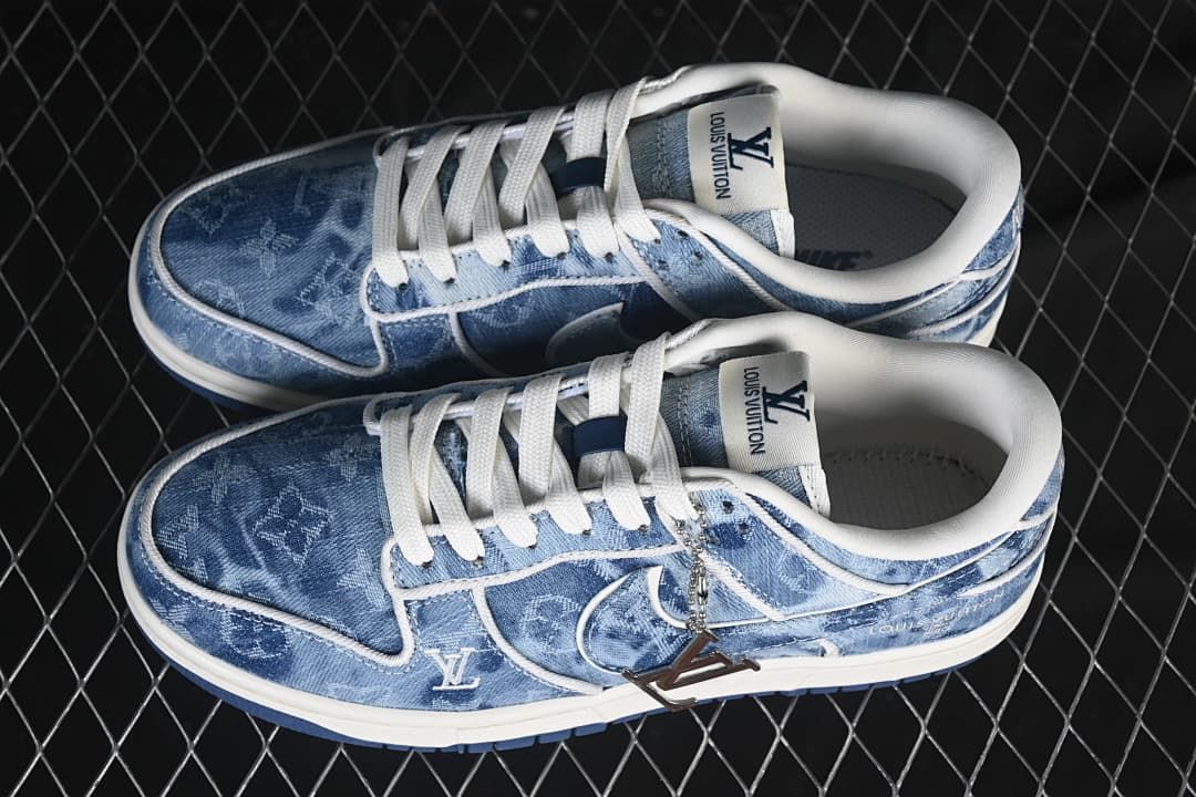 Pair of blue denim-pattern low-top sneakers with white laces, visible branding, and decorative side charm