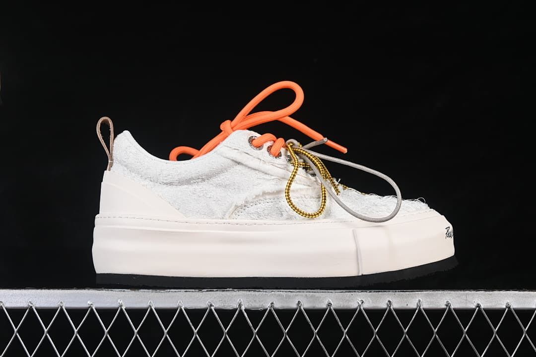 Side profile of a white textured low-top sneaker with a thick platform sole.