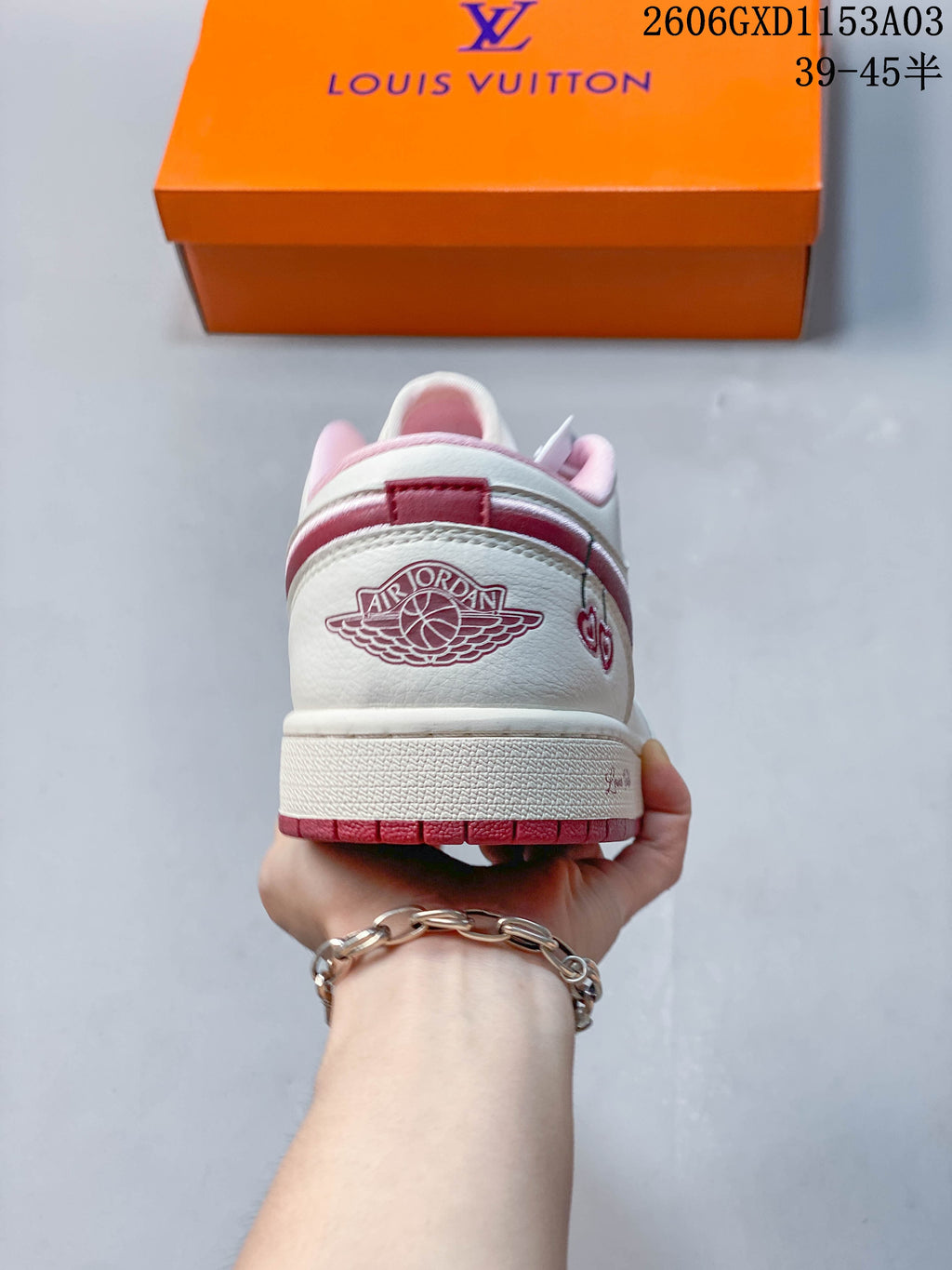 Rear view showing the heel panel and pink outsole of a white low-top sneaker.