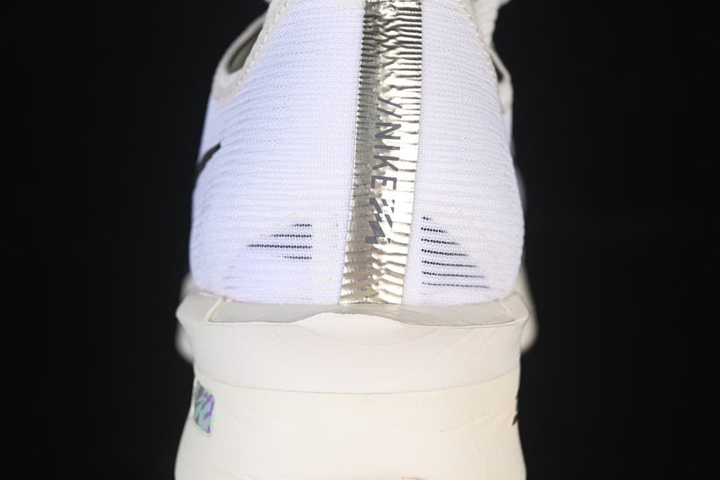 Rear view of the white shoe with metallic-look heel detail and sculpted sole
