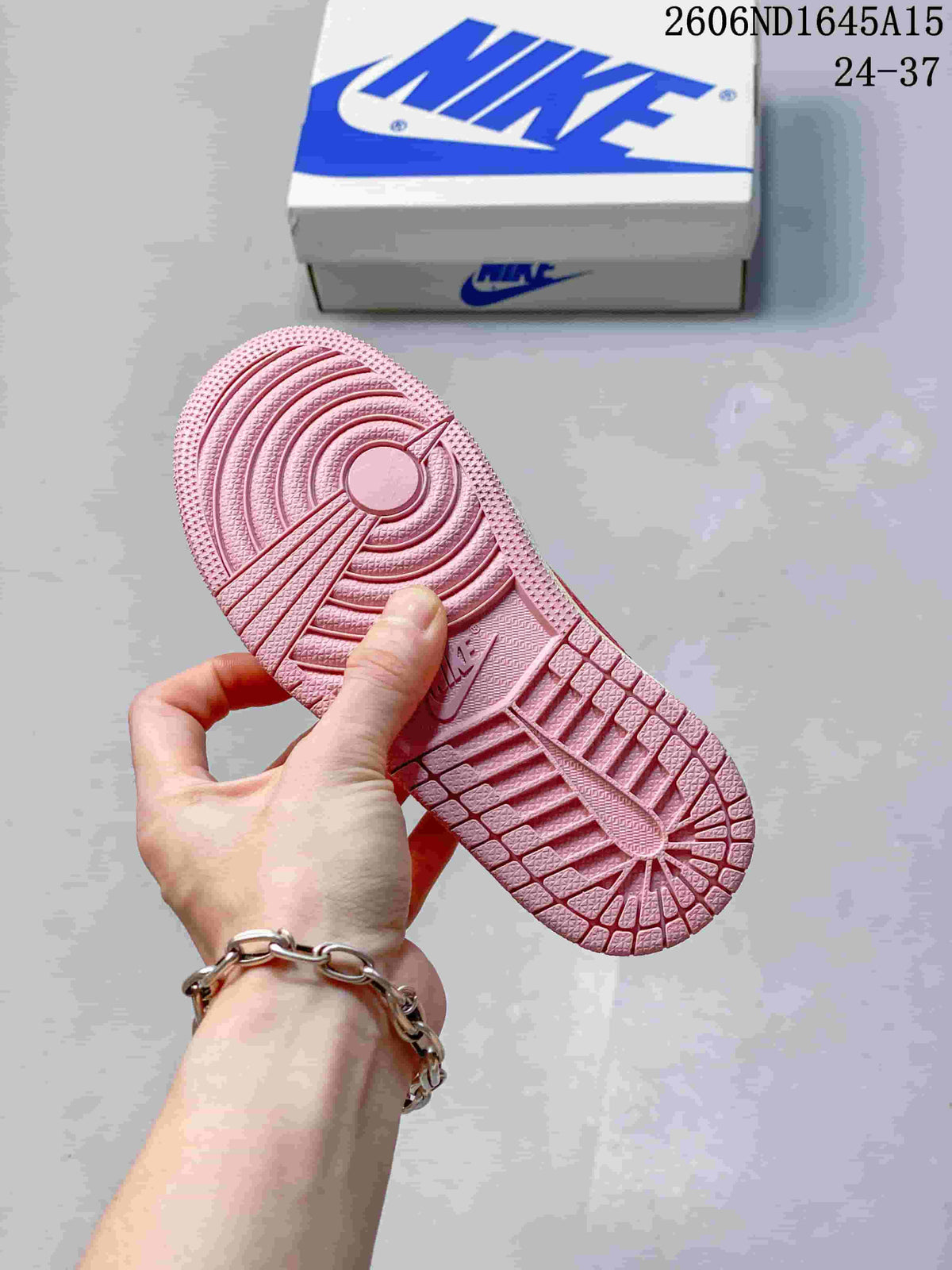 Close-up of the pink outsole with circular and grid-like tread patterns.