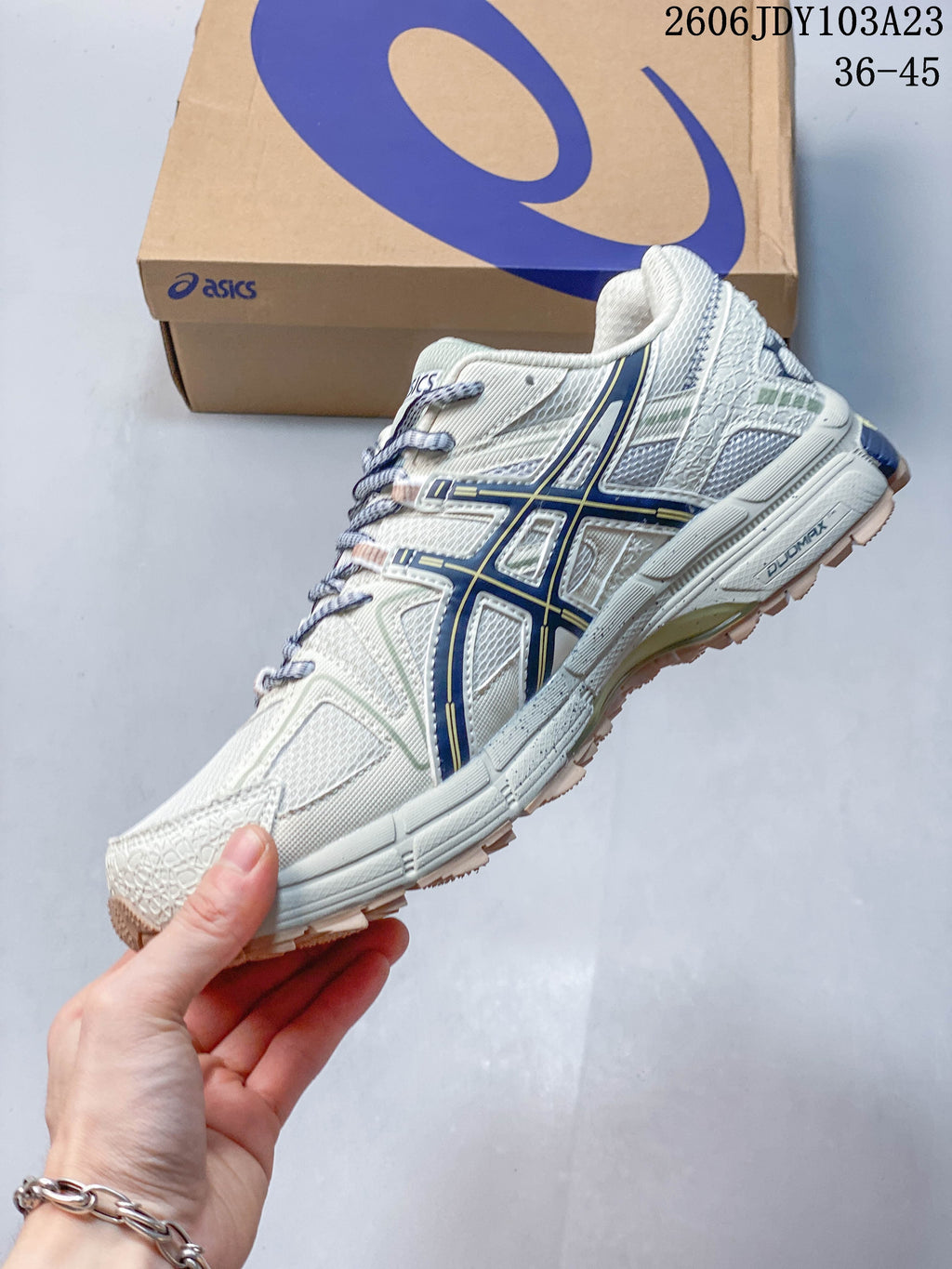 Side profile of a cream sneaker with navy side stripes and textured outsole