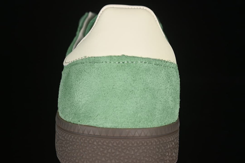 Rear view of the green sneaker with cream heel detail and brown sole
