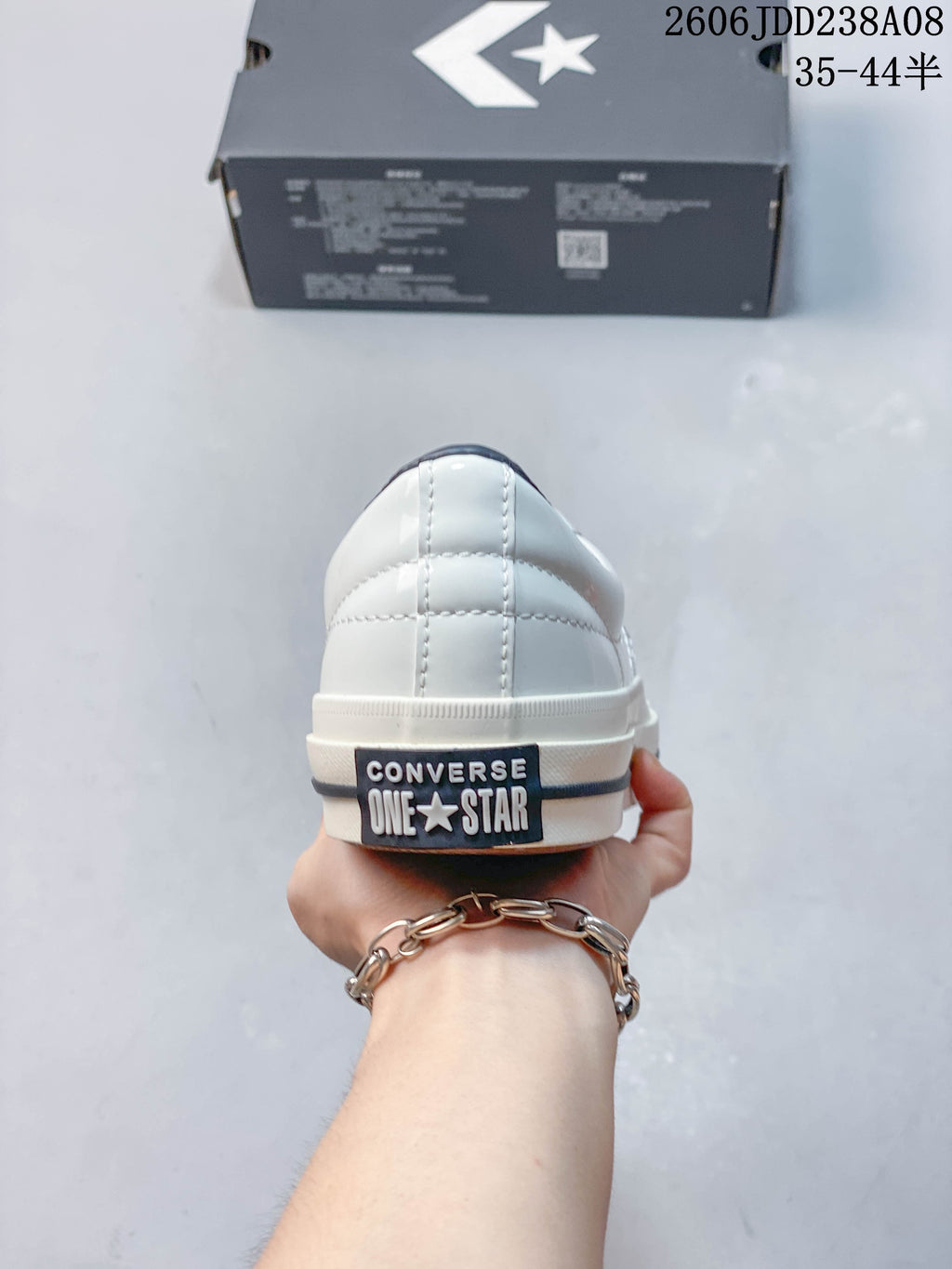 Rear view of a white Converse One Star sneaker with branded heel patch
