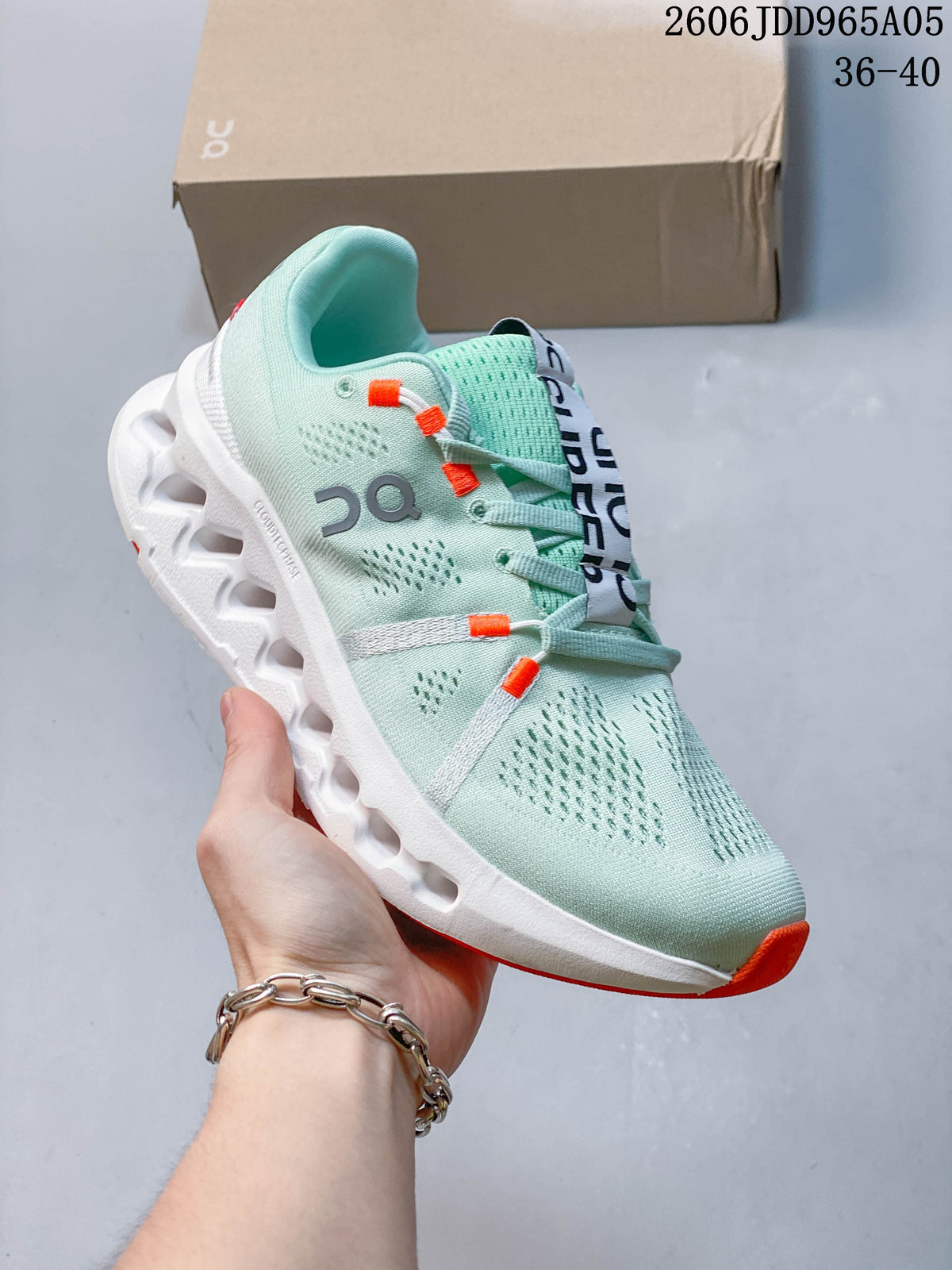 Angled side view of the mint shoe with white sole and orange accents