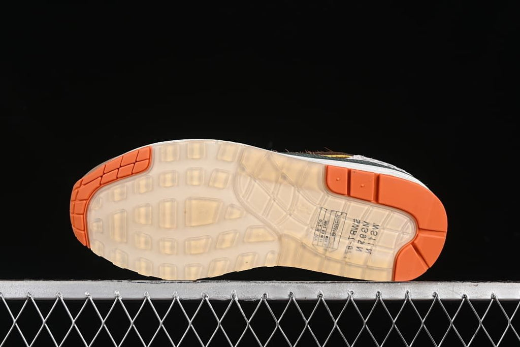 Underside view showing translucent outsole sections and orange traction areas.