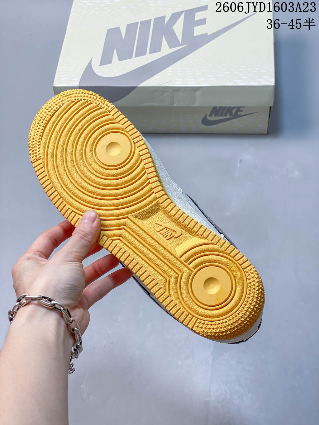 Golden gum-colored outsole shown beside the shoe box