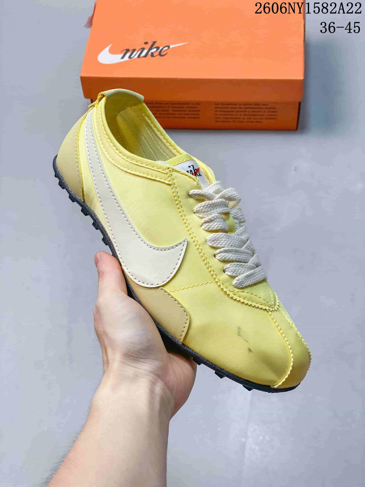 Close view of a yellow Nike low-top sneaker with a light-colored Swoosh and textured outsole