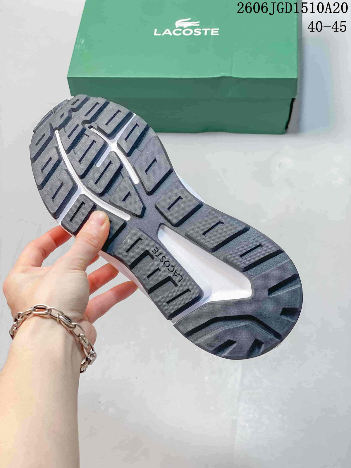 Close-up of the dark treaded outsole on a white Lacoste sneaker