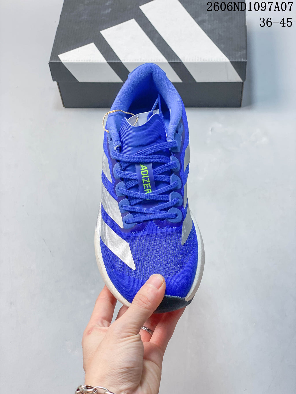 Front view of a blue lace-up running shoe with silver side stripes; image overlay shows 36–45.