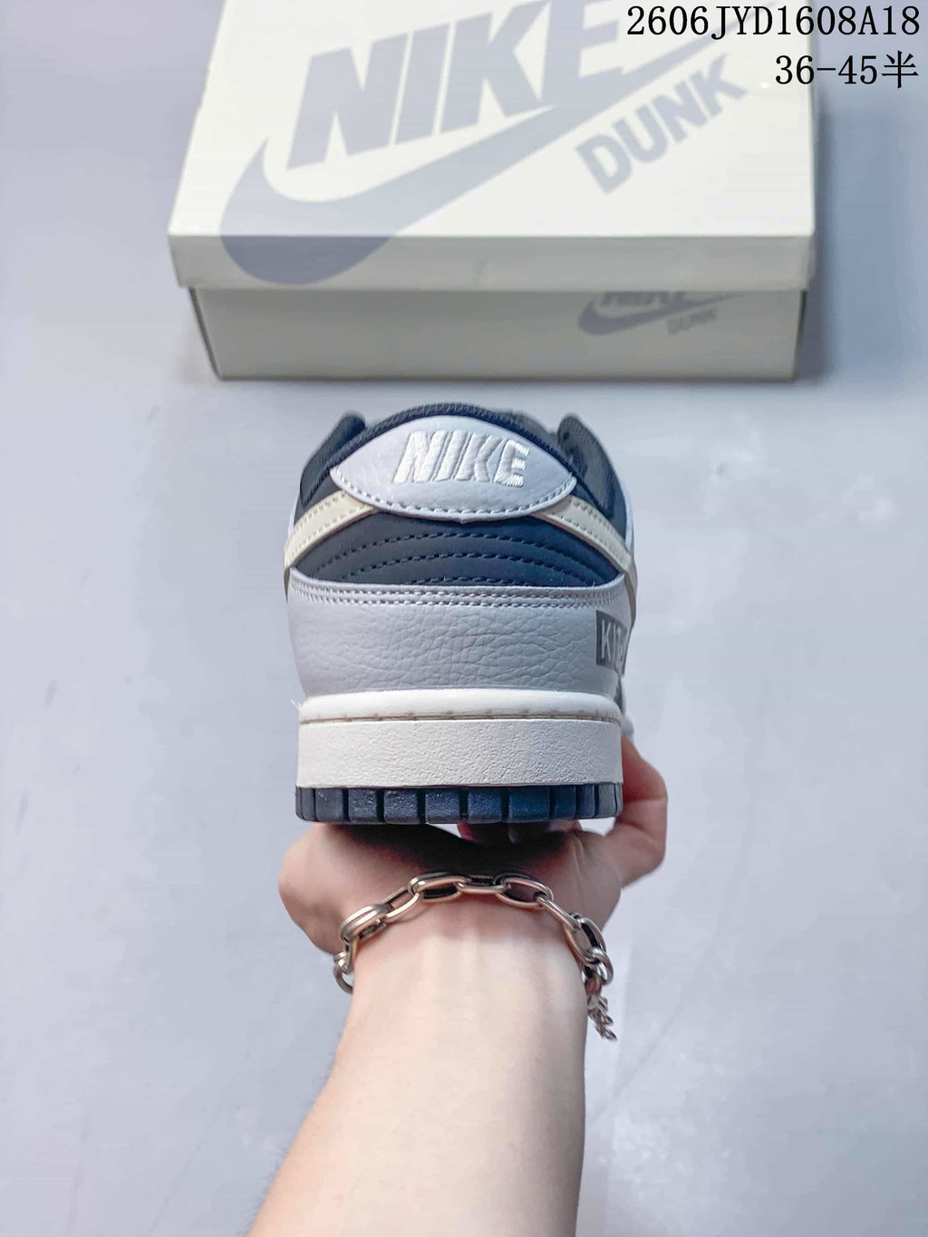 Rear view of a navy and grey low-top sneaker showing heel branding