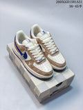 Pair of cream, taupe, and blue low-top Nike sneakers on a patterned box