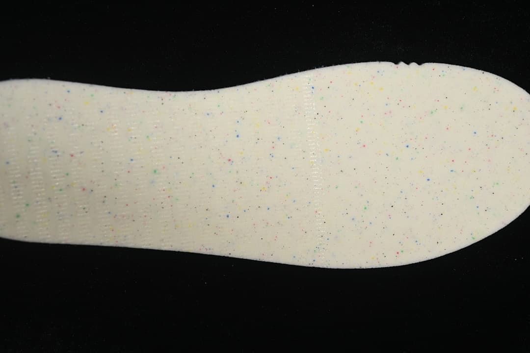 Close-up of a light-colored insole with small multicolor speckles