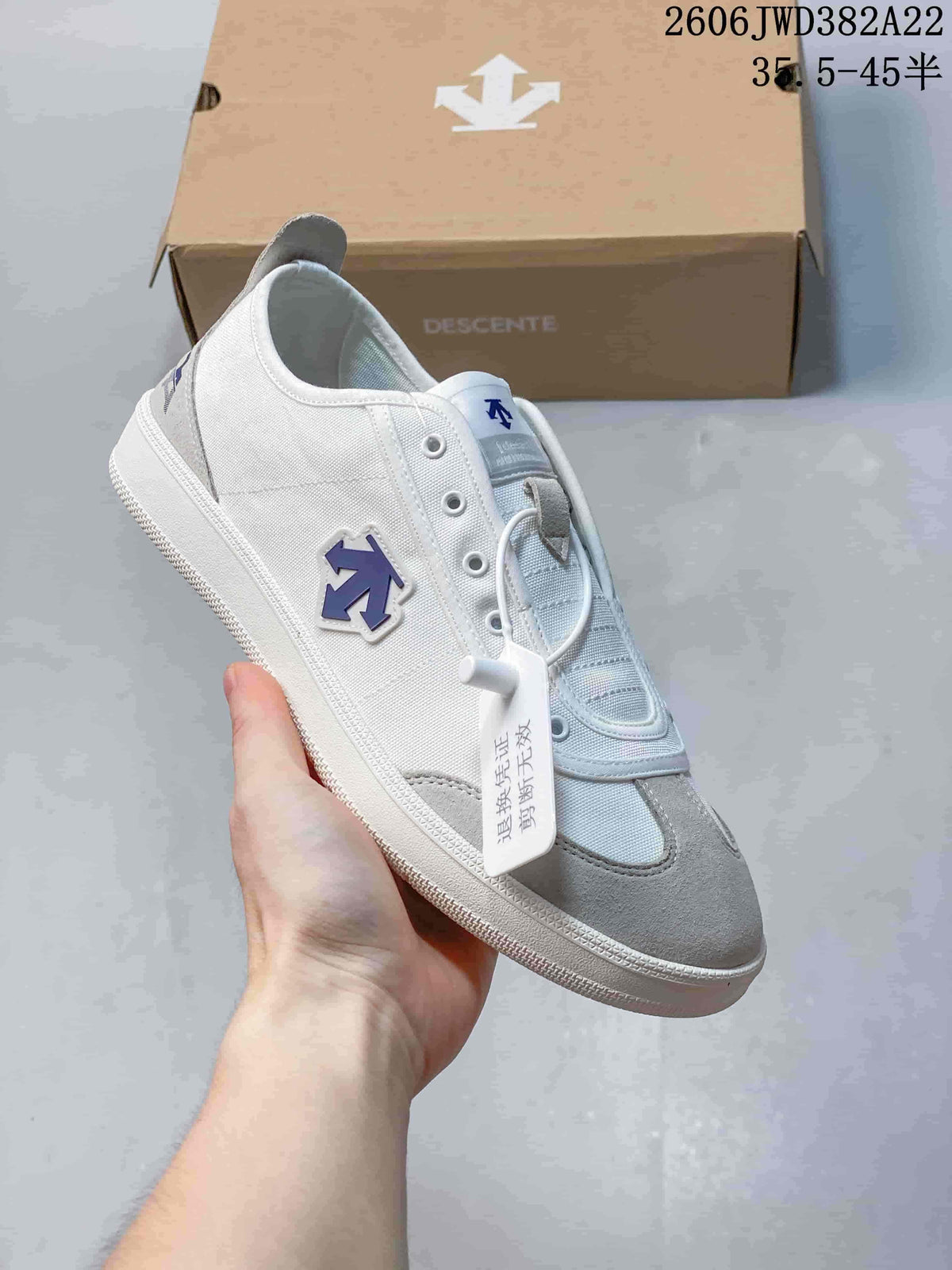 Angled side view highlighting the white upper, grey toe overlay, and blue side logo