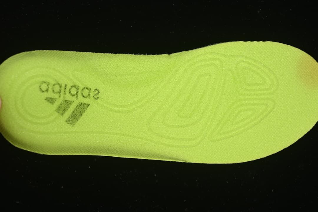 Bright yellow-green insole with adidas branding and a molded footbed pattern.