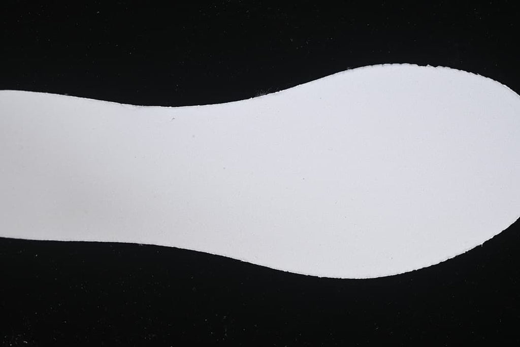Close-up of a pale shoe-shaped insert against a dark background