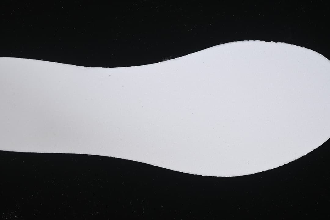 Close-up of a pale shoe-shaped insert against a dark background