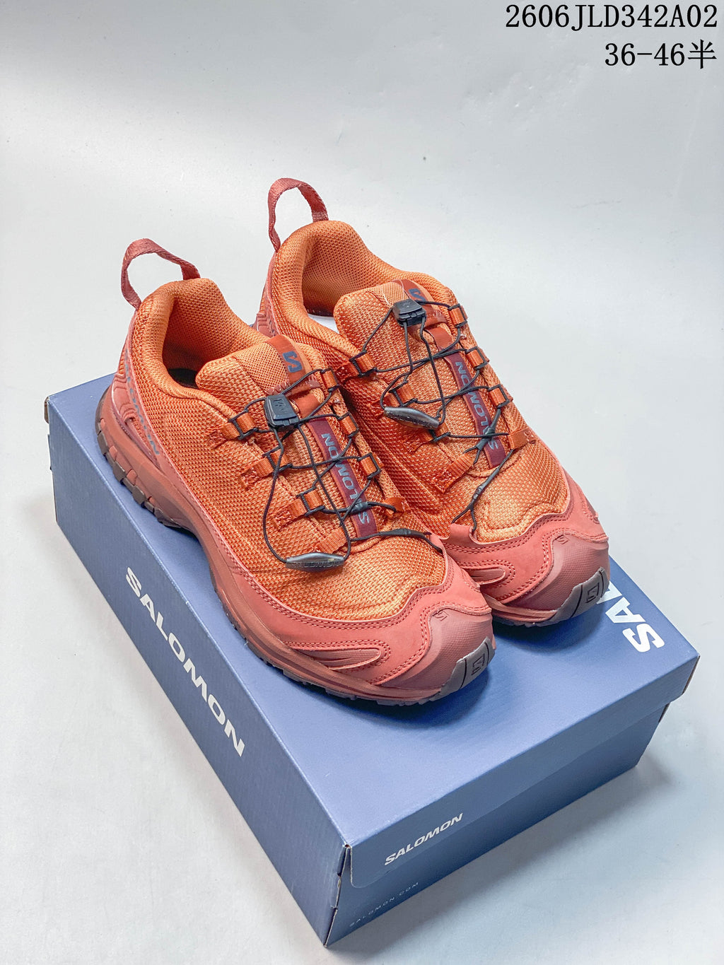 Orange and dark gray Salomon trail running shoes shown together.