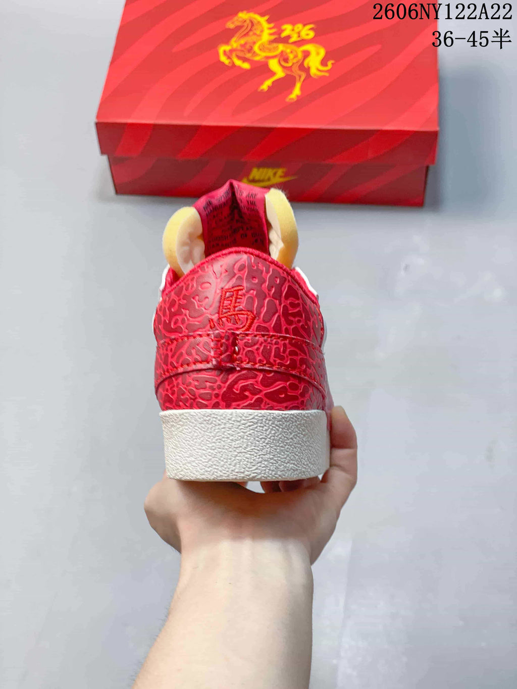 Rear view of the sneaker showing red patterned heel overlays and a white outsole.