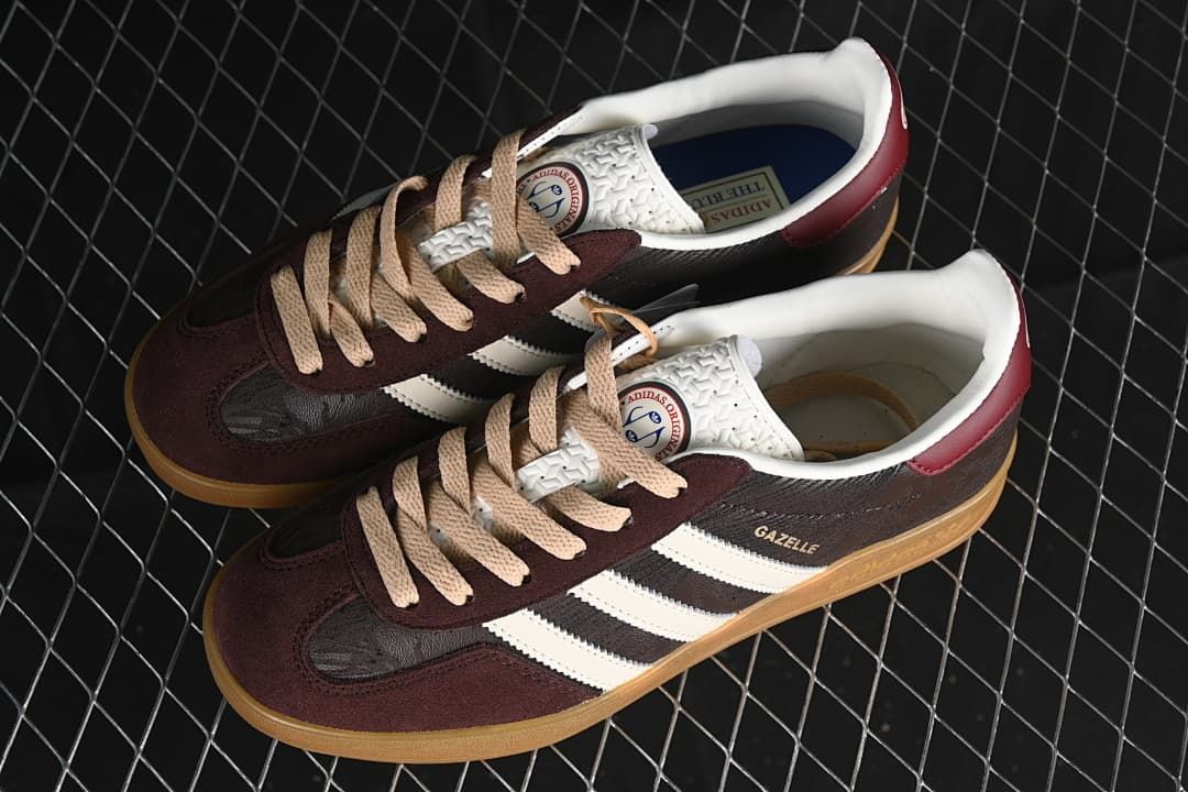 Pair of Gazelle Indoor sneakers with burgundy and dark brown panels, beige laces, and gum soles.
