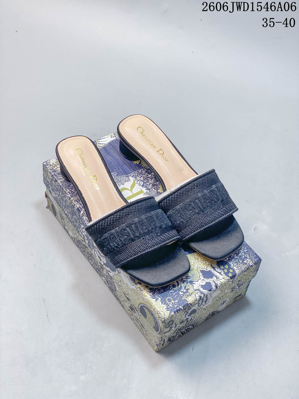 Pair of dark navy embroidered Dior Dway-style mule sandals with square toes, shown on a patterned box