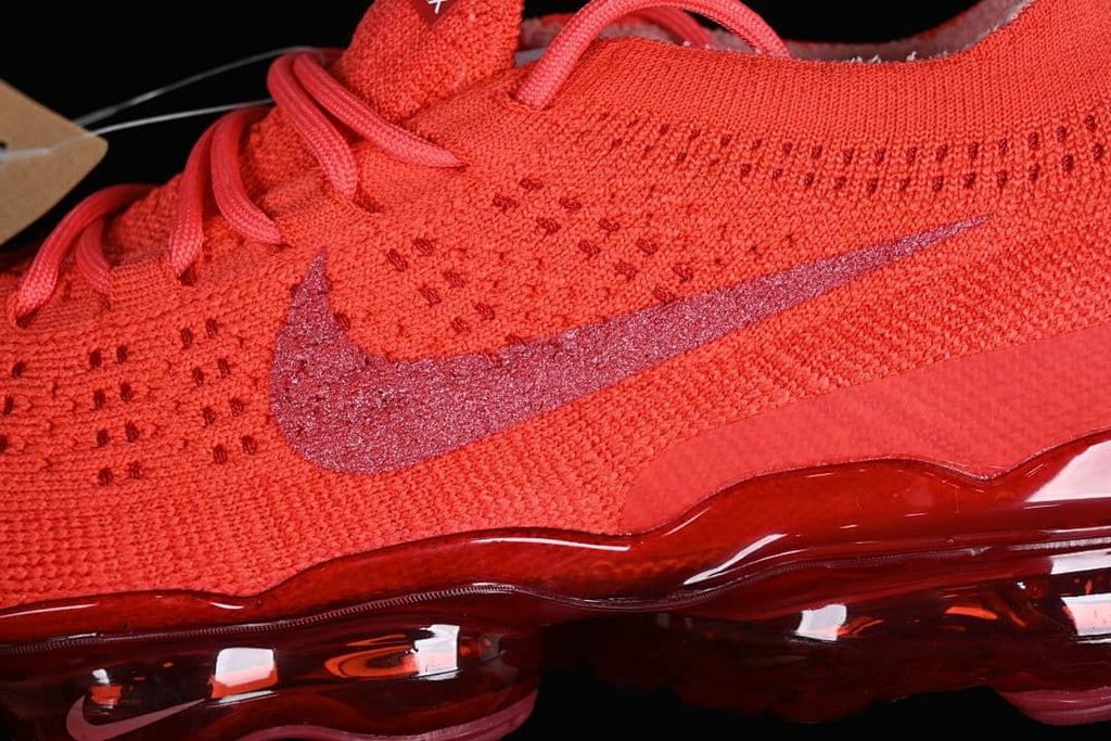 Close-up of the red knit upper, side Swoosh, and translucent sole