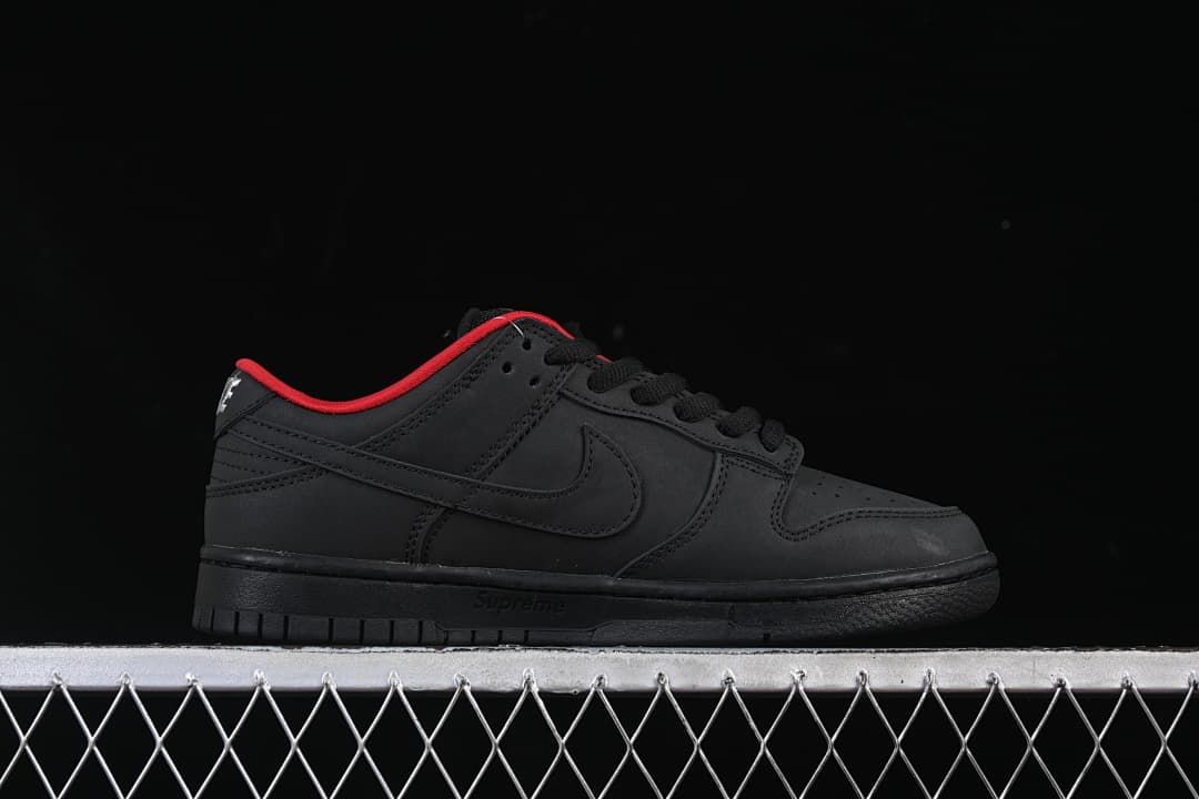 Side profile of the black low-top shoe with red collar trim