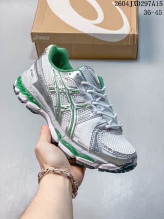 ASICS low-top sneaker with green accents, gray paneling, and a contrasting outsole.