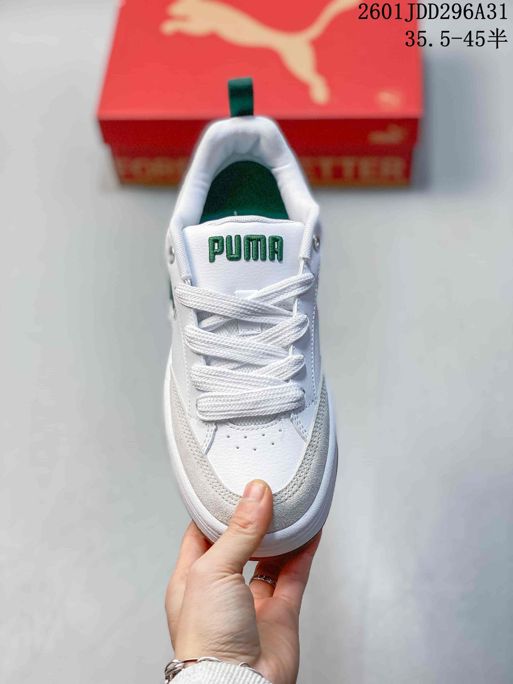 Front view showing white laces, green tongue branding, and light neutral overlays
