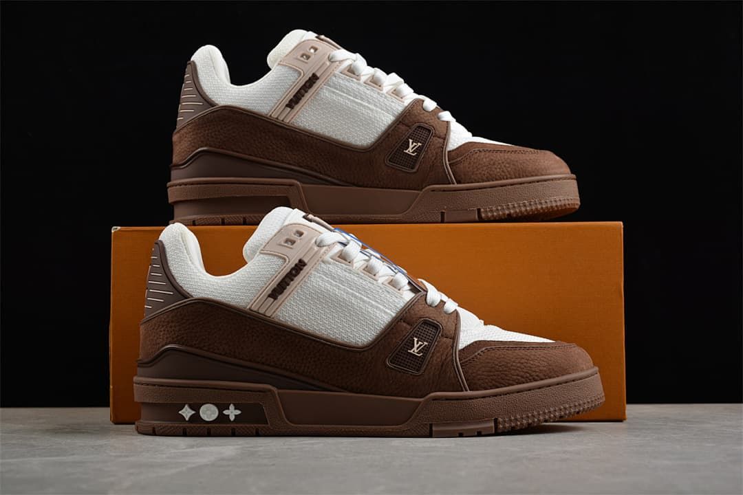 Two brown and white sneakers displayed on and in front of a box.