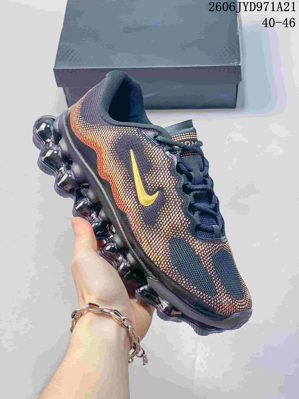 Side view of a patterned navy, red and gold Nike Air Liquid Max shoe with a segmented bubble-like sole; image displays a size range.