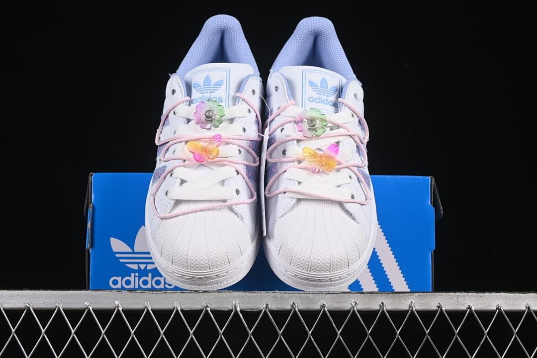 Front view of the pair with shell toes and colorful lace ornaments