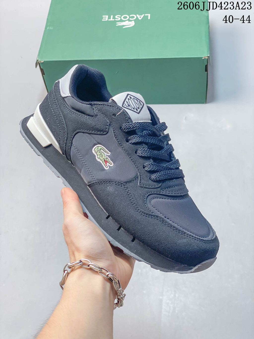 Angled side view of a navy Lacoste sneaker with a crocodile emblem and lace-up front.