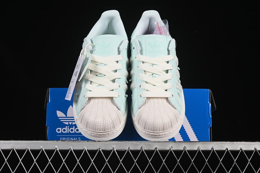 Front view of the pair showing shell toes and mint green uppers