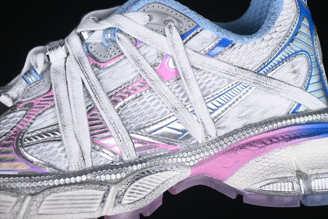 Close-up of the sneaker’s white, silver, blue and pink side panels and laces