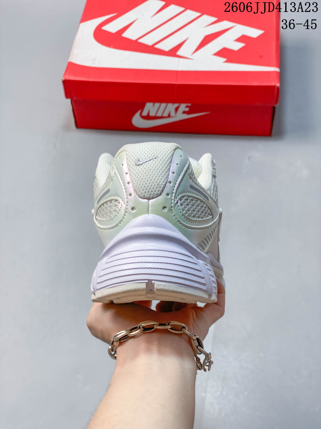 Rear view showing the padded heel and sculpted sole of a light-colored Nike Air Zoom Winflo 12 shoe.
