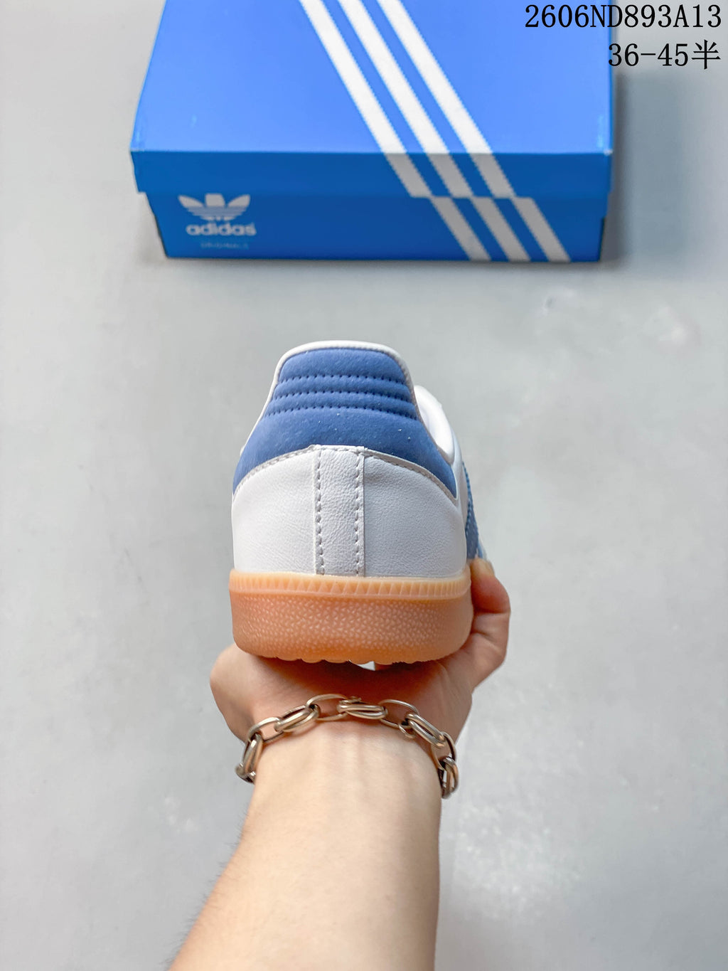Rear view of the sneaker showing the blue heel panel and gum-colored outsole.