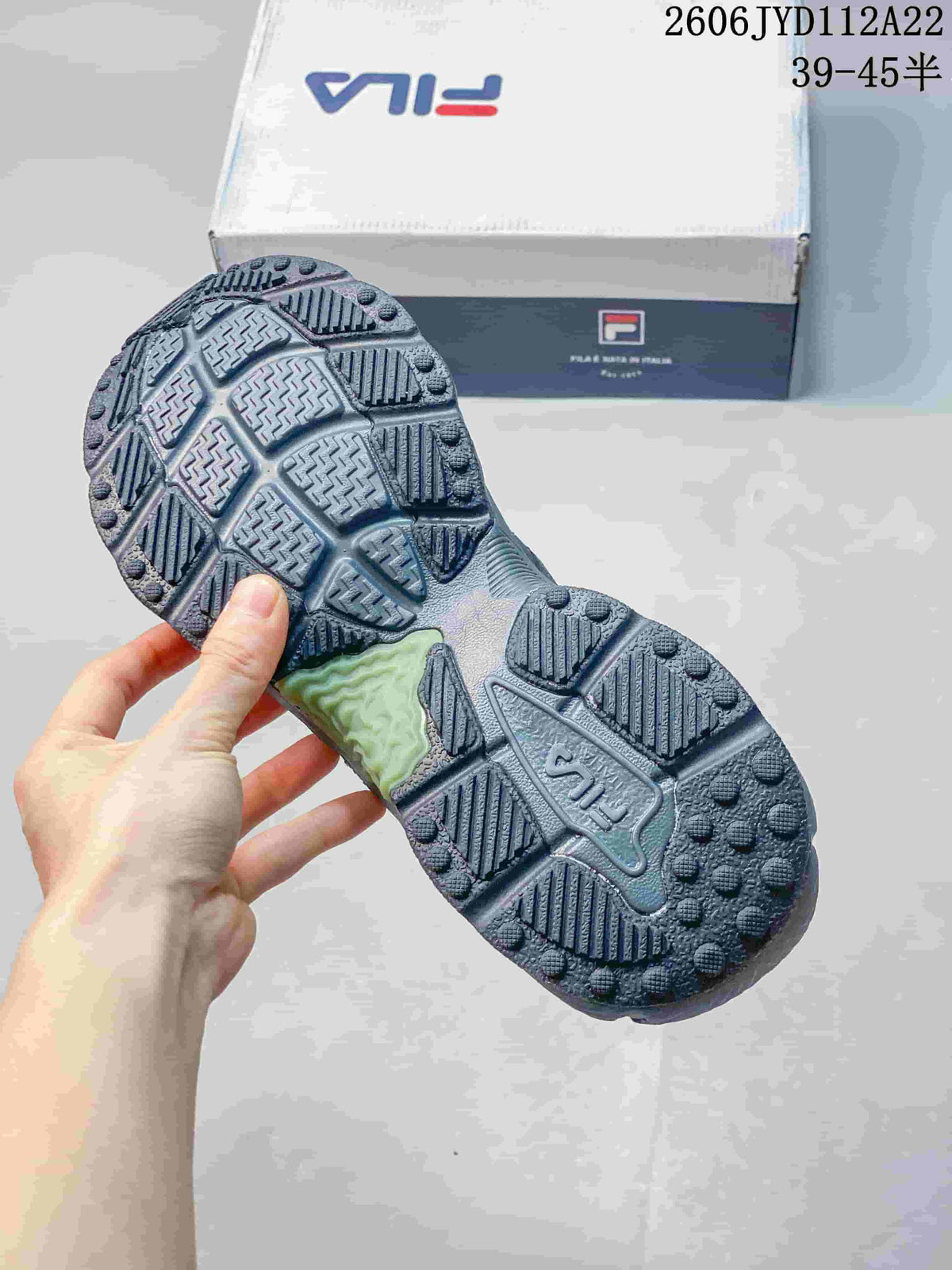 Close-up of the patterned outsole on a charcoal FILA sneaker