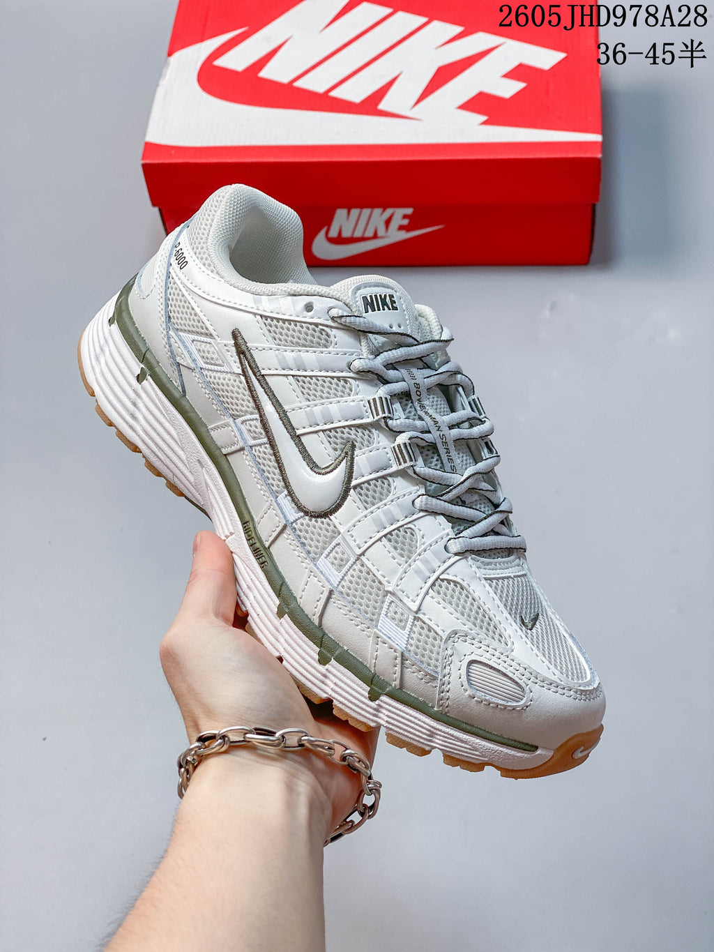 Angled side view of the white and olive-accented Nike Initiator shoe