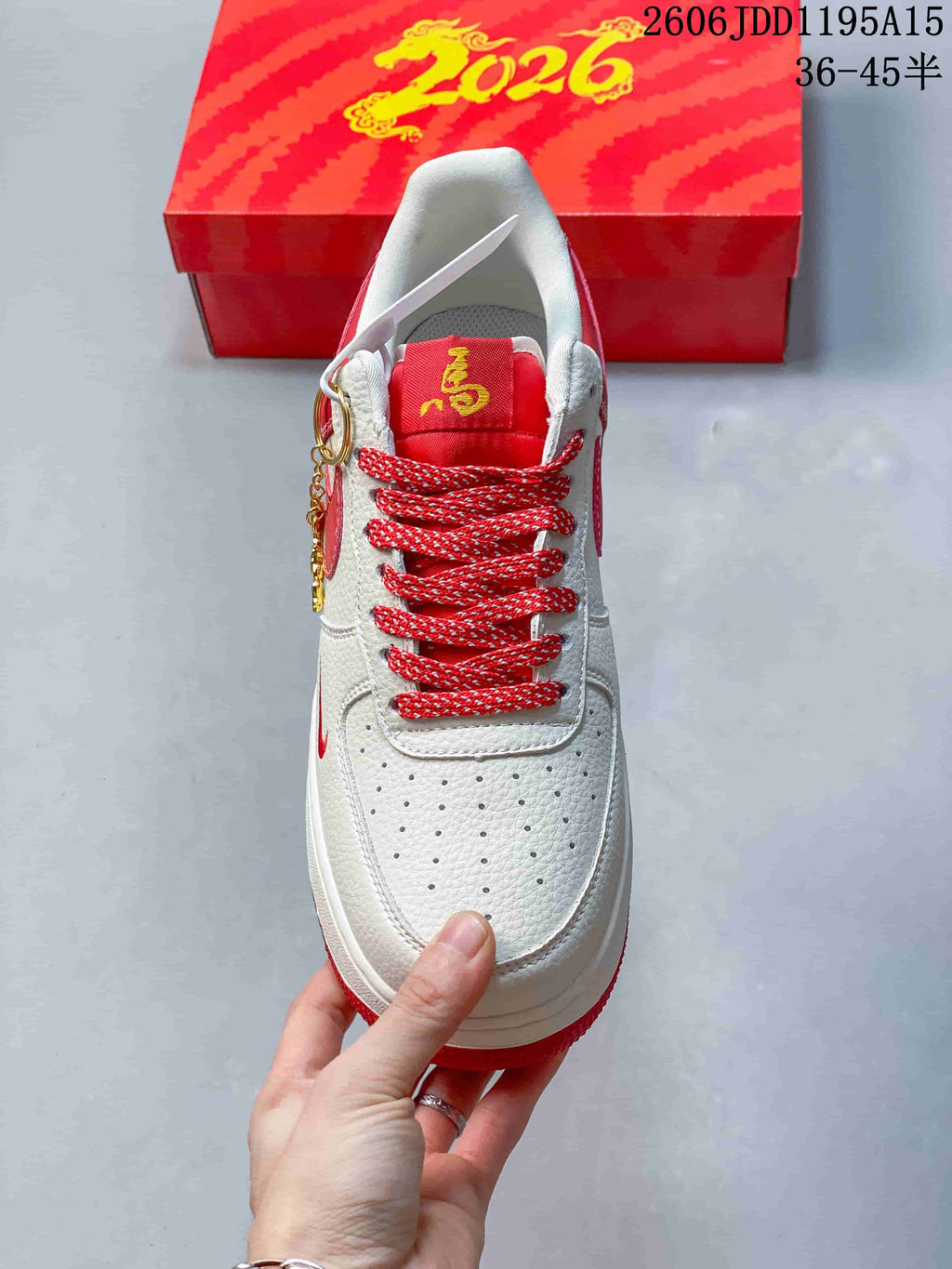Top view showing perforated toe, red patterned laces, and decorative charm