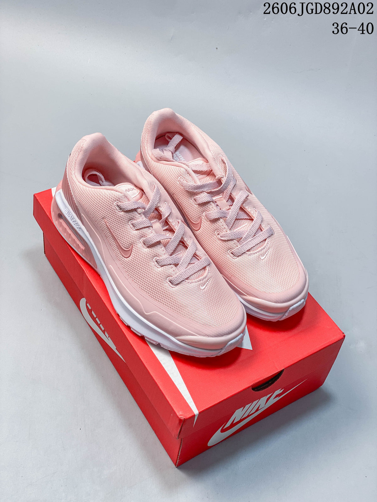 Pair of pink Nike Air Max BIA shoes displayed on a red shoebox