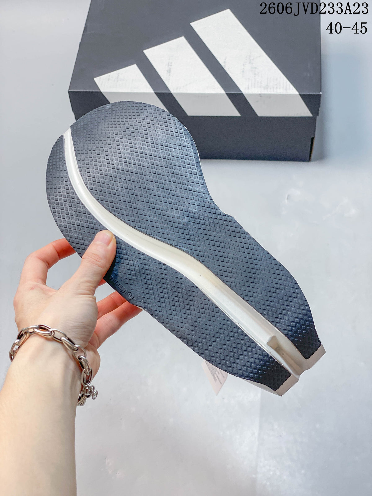 Close-up of the dark textured outsole on a white adidas running shoe