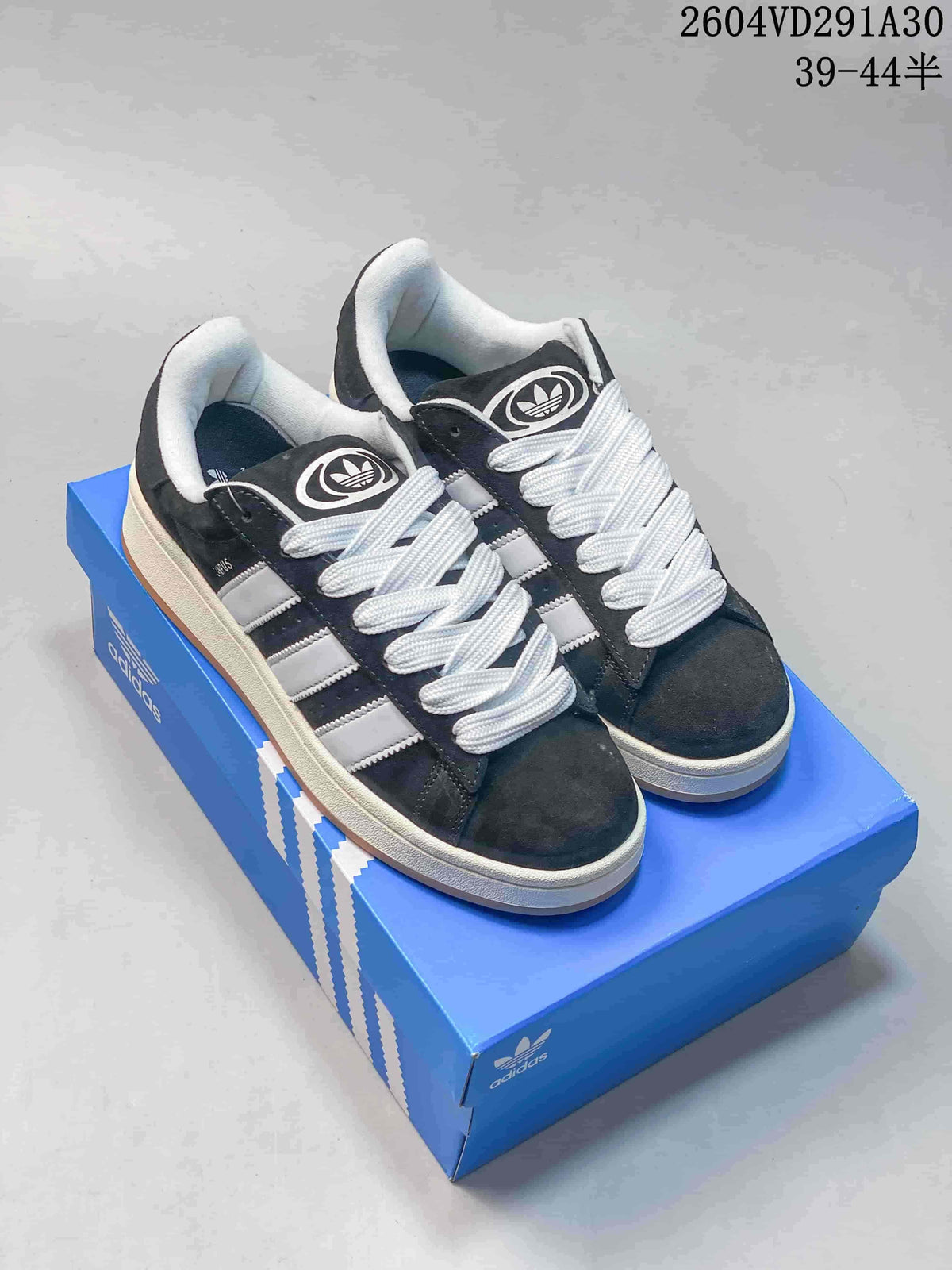 Pair of dark navy Adidas Campus sneakers with white stripes and laces.